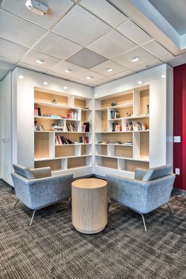 The edge A library interior featuring two chairs and a table, creating a cozy reading or study area.