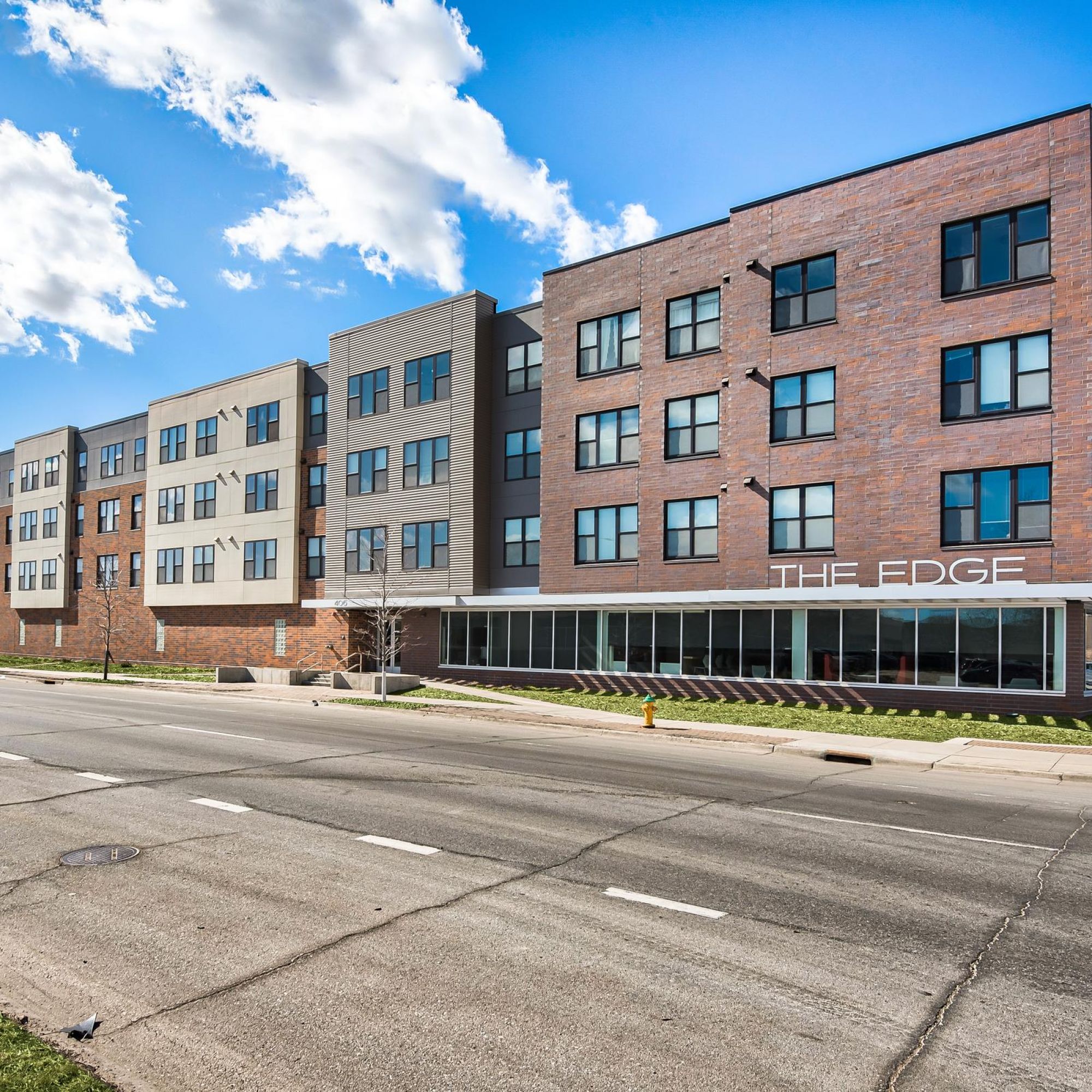 The Edge New apartment building at the street corner, featuring modern architecture and large windows.