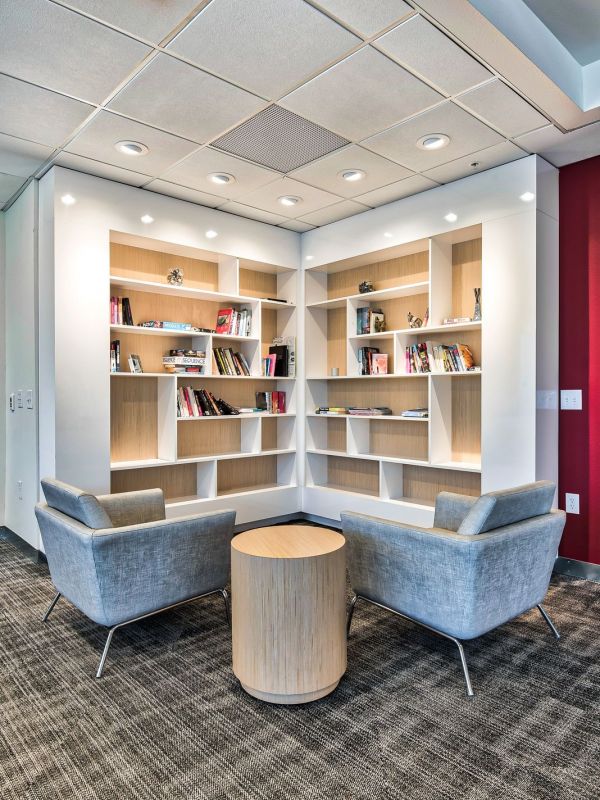 The edge A library interior featuring two chairs and a table, creating a cozy reading or study area.