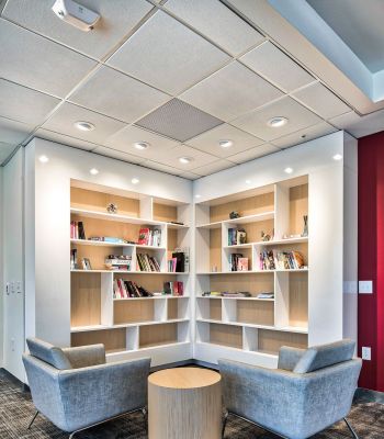 The edge A library interior featuring two chairs and a table, creating a cozy reading or study area.